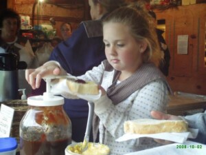 Julie puts homemade apple butter on a slice of hot bread for a customer.