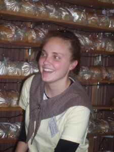 Sarah Beth Slabach takes a break in front of the shelves of loaves.